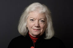 A headshot of Dr. Sue Carter, set against a dark background.